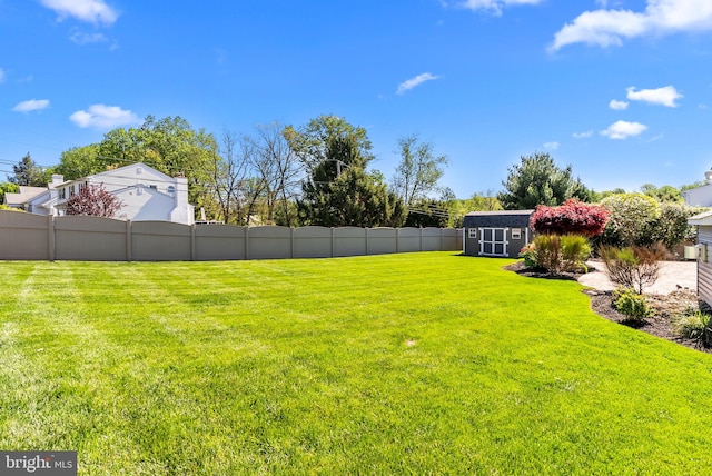 view of yard featuring fence, an outbuilding, and a shed