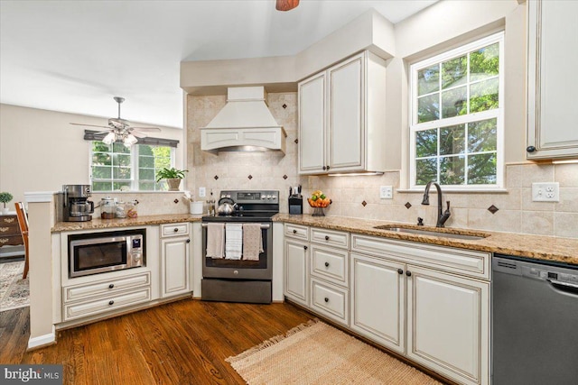 kitchen with tasteful backsplash, custom range hood, a sink, dark wood finished floors, and appliances with stainless steel finishes