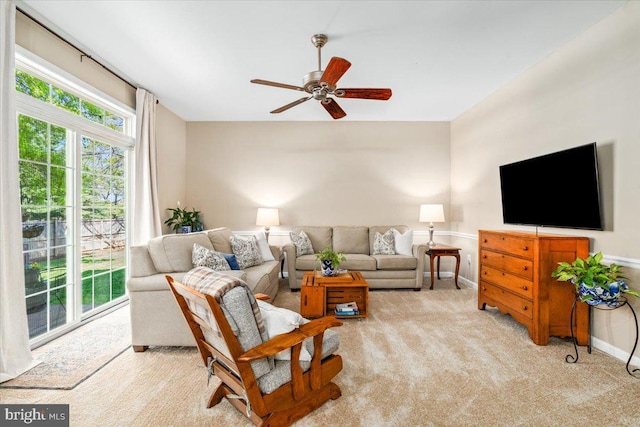 living room with carpet flooring, a ceiling fan, baseboards, and plenty of natural light