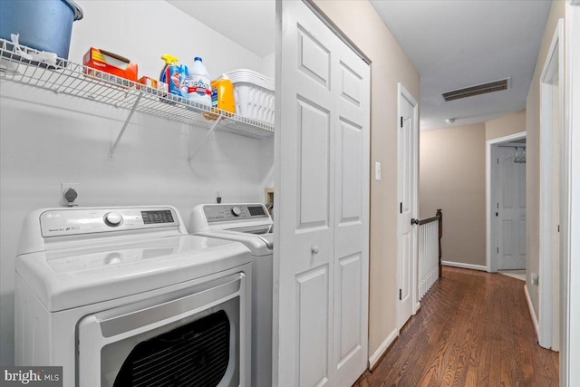 laundry area with laundry area, baseboards, dark wood-type flooring, visible vents, and washing machine and dryer