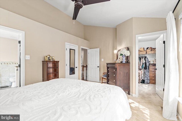bedroom featuring a closet, ceiling fan, light colored carpet, a spacious closet, and ensuite bath