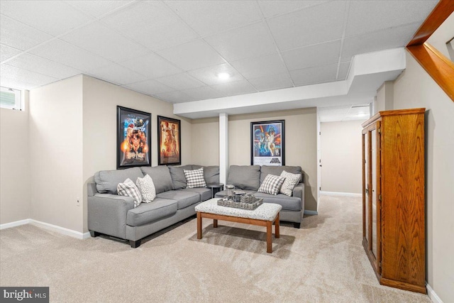 living room with carpet flooring, baseboards, and a paneled ceiling