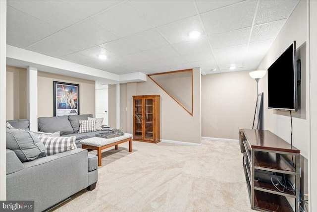 living room with carpet floors, baseboards, and a drop ceiling