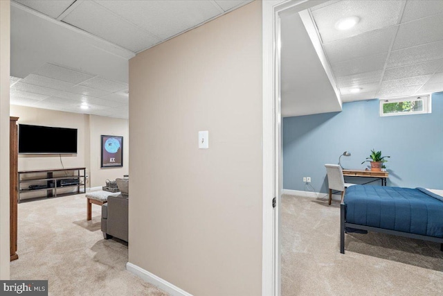interior space featuring baseboards, carpet, and a paneled ceiling