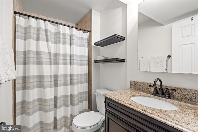 bathroom featuring toilet, a shower with curtain, and vanity
