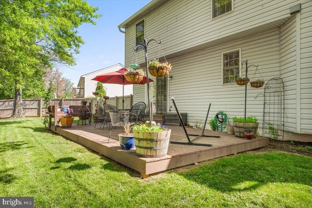 deck featuring a lawn and fence