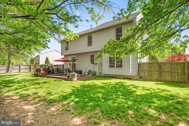 back of house featuring a lawn, a deck, and a fenced backyard