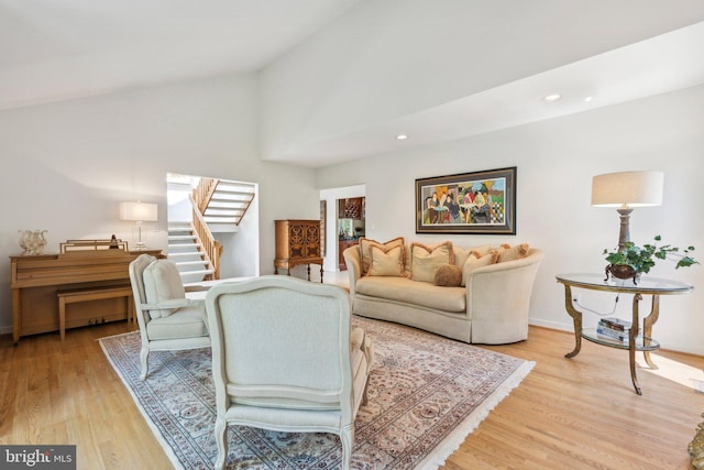 living room with light wood finished floors, high vaulted ceiling, recessed lighting, baseboards, and stairway