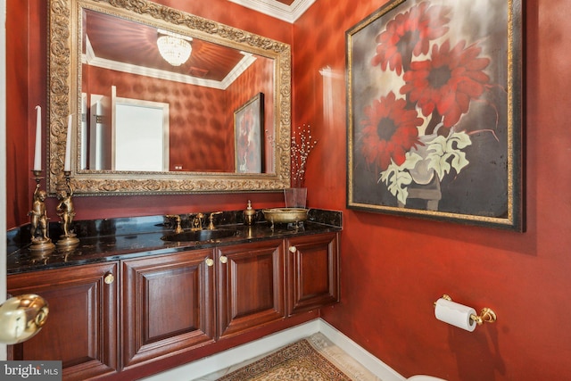 bathroom with crown molding, baseboards, and vanity
