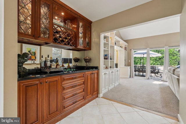 bar with light colored carpet, wet bar, baseboards, and light tile patterned flooring