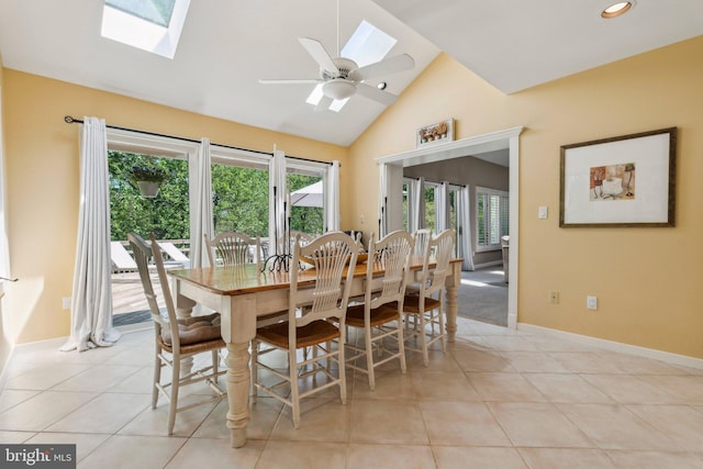 dining area featuring a skylight, light tile patterned floors, baseboards, high vaulted ceiling, and recessed lighting