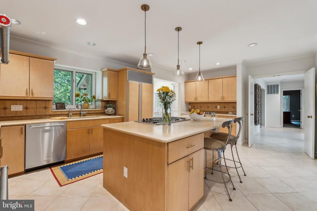 kitchen featuring decorative backsplash, ornamental molding, a kitchen bar, light countertops, and appliances with stainless steel finishes