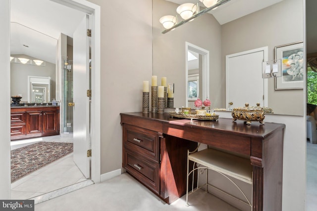 bathroom with baseboards, a shower stall, lofted ceiling, and vanity