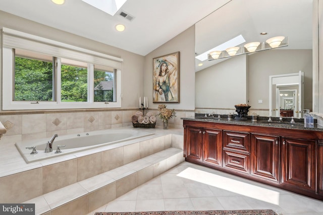bathroom featuring visible vents, lofted ceiling with skylight, tile patterned floors, a bath, and a sink