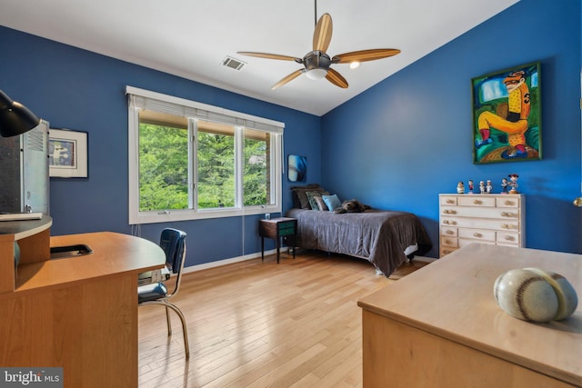 bedroom featuring visible vents, wood finished floors, baseboards, ceiling fan, and vaulted ceiling