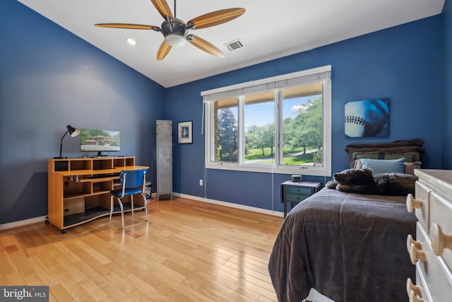 bedroom with baseboards, lofted ceiling, light wood-style flooring, and visible vents