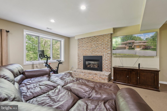carpeted living room with visible vents, recessed lighting, baseboards, and a fireplace