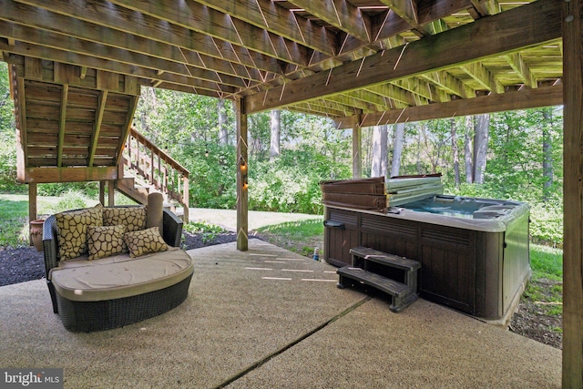 view of patio / terrace featuring a hot tub and stairs