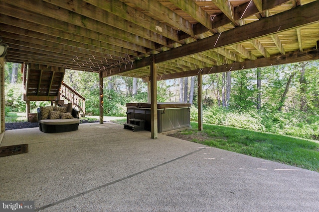 view of patio with a hot tub and stairway