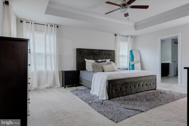 5735 River Shark Ln, Waldorf, MD 20602 - carpeted bedroom featuring baseboards, a tray ceiling, ensuite bathroom, and a ceiling fan