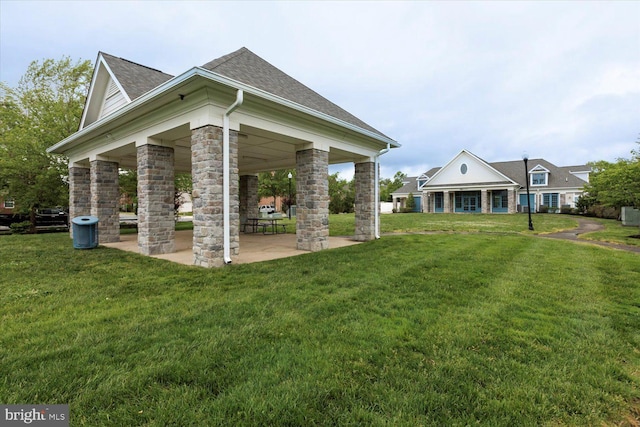 5735 River Shark Ln, Waldorf, MD 20602 - view of side of property with a yard, roof with shingles, stone siding, and a patio