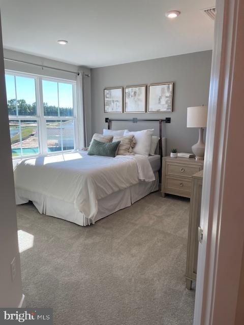 bedroom with visible vents, recessed lighting, and light carpet