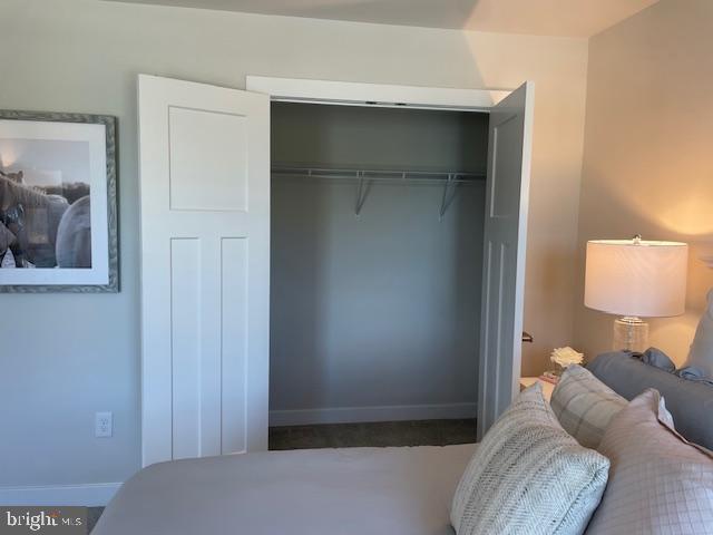 bedroom featuring baseboards and a closet