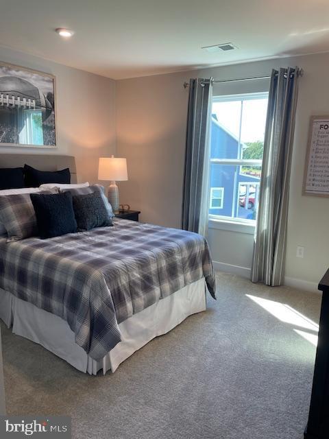 carpeted bedroom with visible vents and baseboards