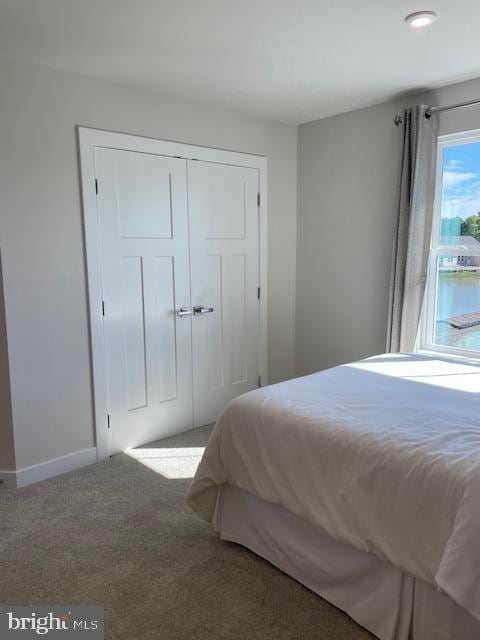 carpeted bedroom featuring baseboards, recessed lighting, and a closet