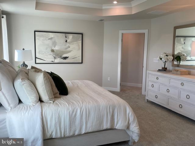 bedroom featuring light colored carpet, a raised ceiling, baseboards, recessed lighting, and ornamental molding