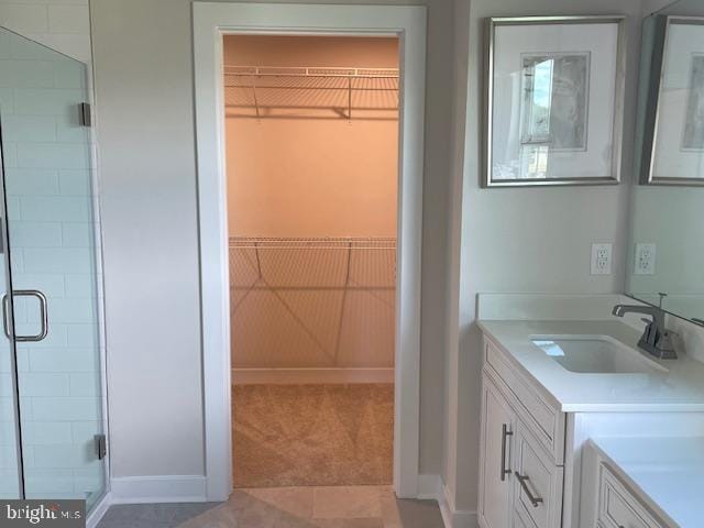 bathroom with baseboards, a shower stall, tile patterned floors, and a spacious closet