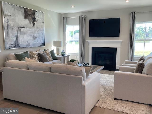 living area with wood finished floors, plenty of natural light, and recessed lighting