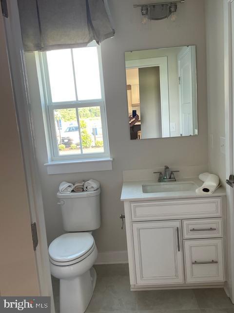bathroom featuring tile patterned floors, toilet, vanity, and baseboards