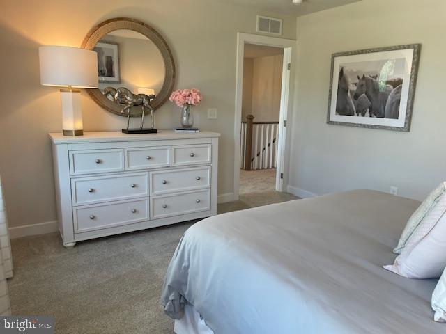 carpeted bedroom featuring visible vents and baseboards