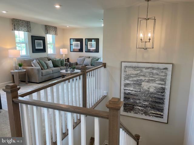 living room featuring recessed lighting, a notable chandelier, carpet, and baseboards