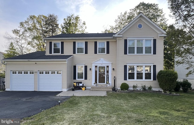 view of front of house featuring a front lawn and aphalt driveway