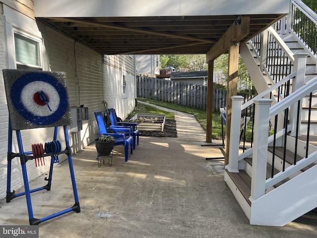 view of patio / terrace featuring fence and stairs