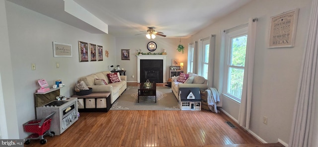 living room featuring hardwood / wood-style floors, visible vents, plenty of natural light, and a ceiling fan