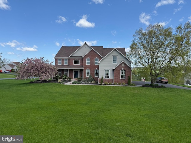 view of front of property featuring brick siding and a front yard