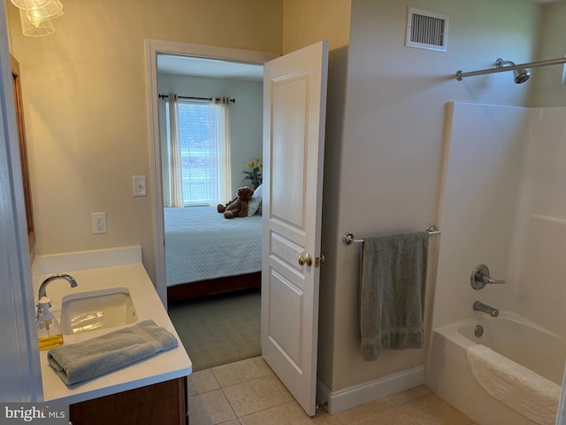 ensuite bathroom featuring washtub / shower combination, vanity, visible vents, baseboards, and tile patterned flooring