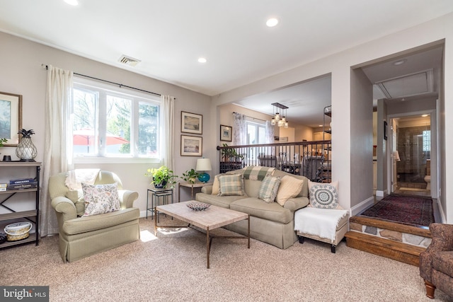 carpeted living room with a chandelier, attic access, recessed lighting, baseboards, and visible vents