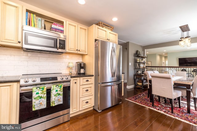 kitchen featuring appliances with stainless steel finishes, backsplash, dark wood finished floors, and cream cabinetry