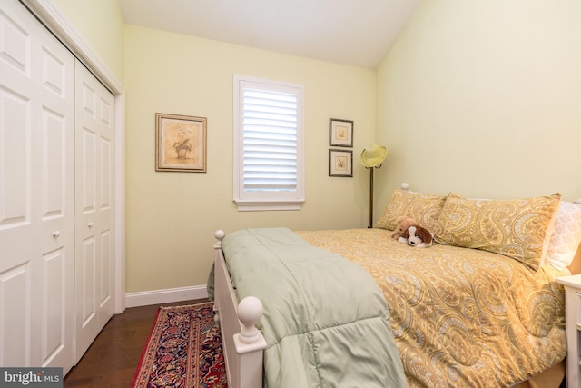 bedroom with a closet, baseboards, and dark wood-type flooring