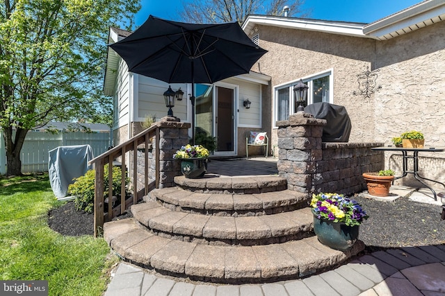 property entrance featuring stucco siding and fence