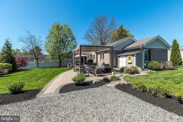 rear view of property featuring a lawn, a patio area, and fence
