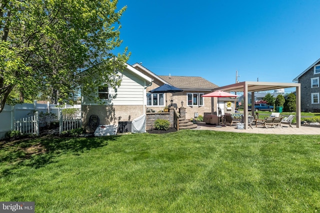 back of house with fence, a yard, and a patio area