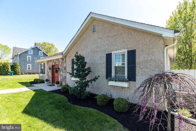exterior space with stucco siding and a front yard