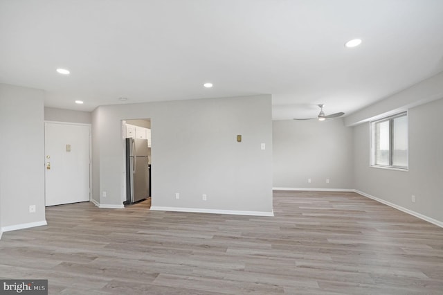 spare room with recessed lighting, a ceiling fan, light wood-style flooring, and baseboards