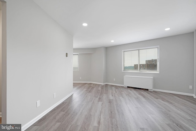 interior space featuring radiator, recessed lighting, wood finished floors, and baseboards