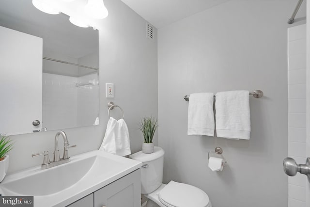 bathroom featuring visible vents, walk in shower, toilet, and vanity